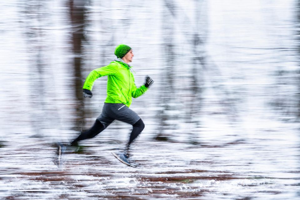 Joggen läuft durch einen verschneiten Wald.  1.4993