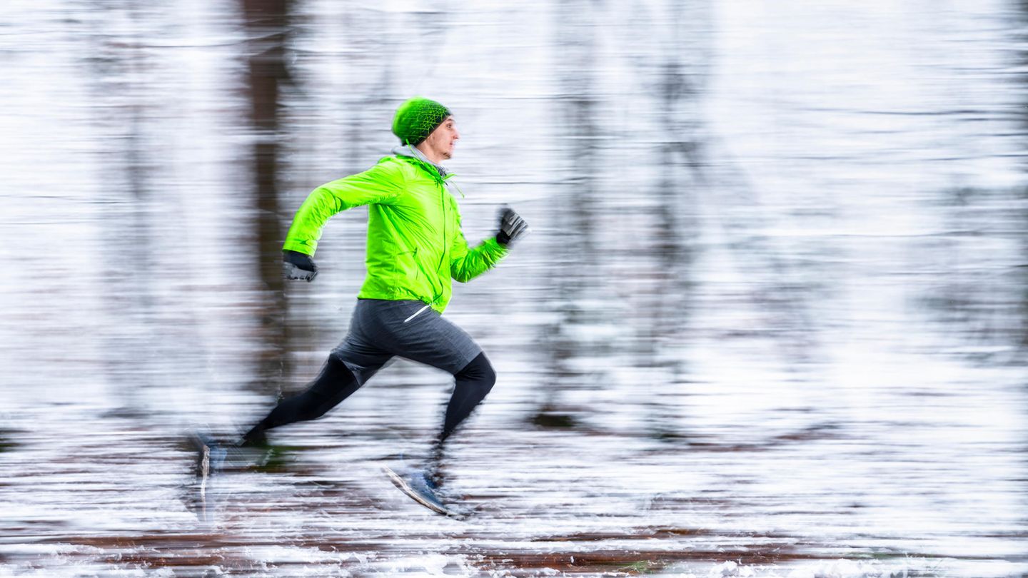 Joggen läuft durch einen verschneiten Wald.