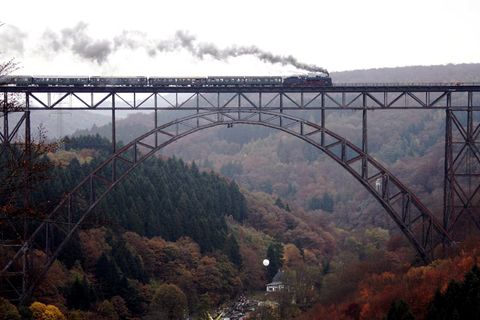 Ein von einer Dampflok gezogener Zug  überquert die Müngstener Brücke