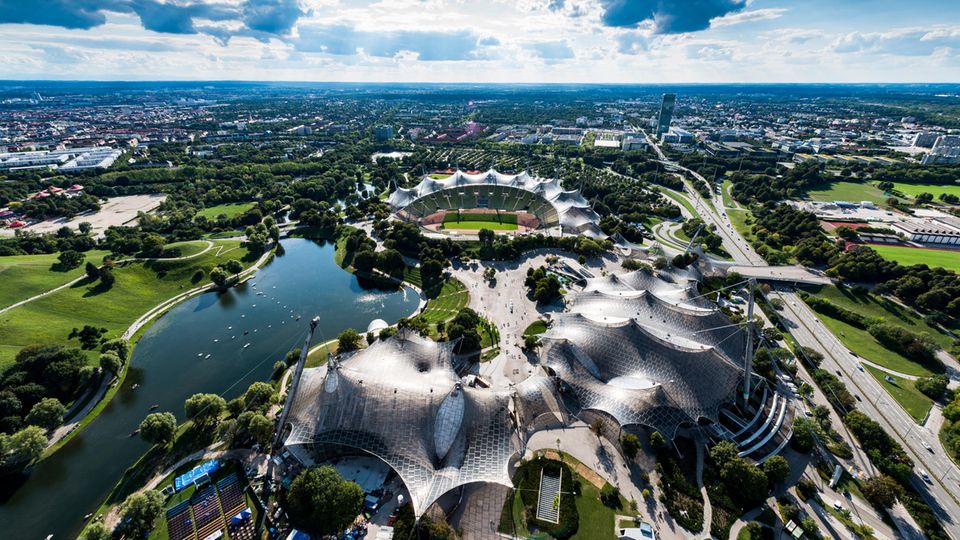 Blick vom Olympiaturm auf das darunter liegende Gelände mit dem Olympiastadion und dem Olympiapark mit Olympiasee