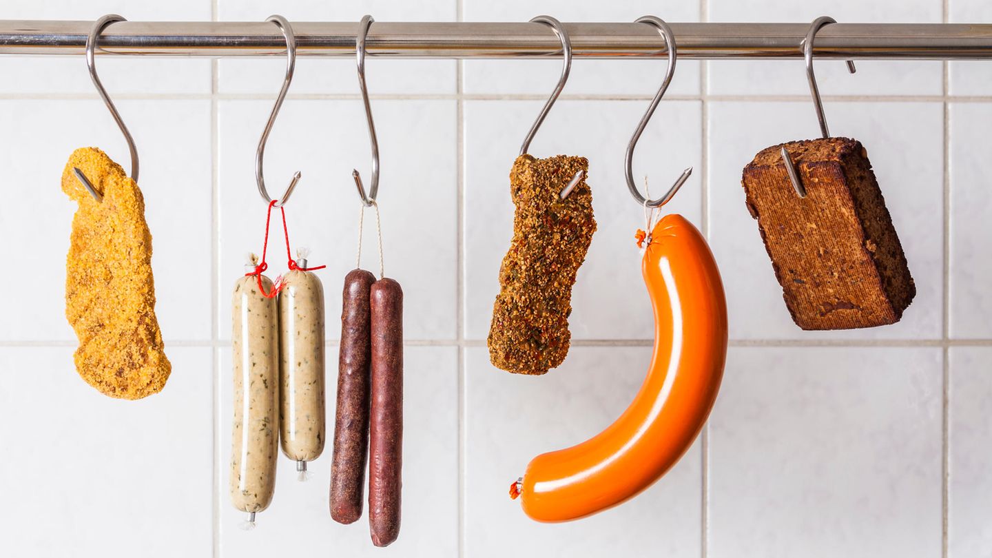 Seschs an Fleischerhaken aufgehängte vegetarische Fleischalternativen