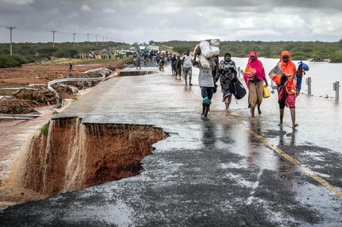Folgen von El Niño: Menschen gehen auf einer zerstörten Strasse entlang