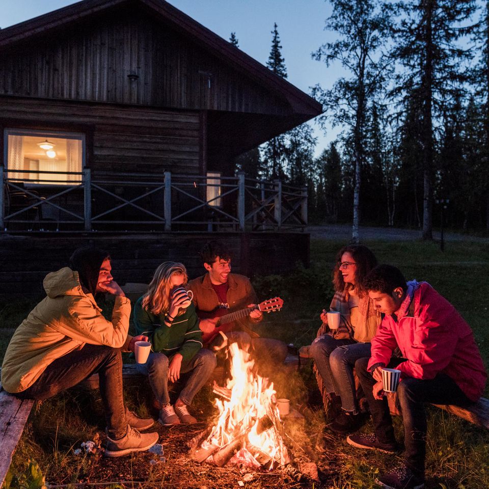 Gruppe von Personen sitzt an einem Lagerfeuer