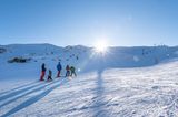 Skifahrende Familie auf der Piste