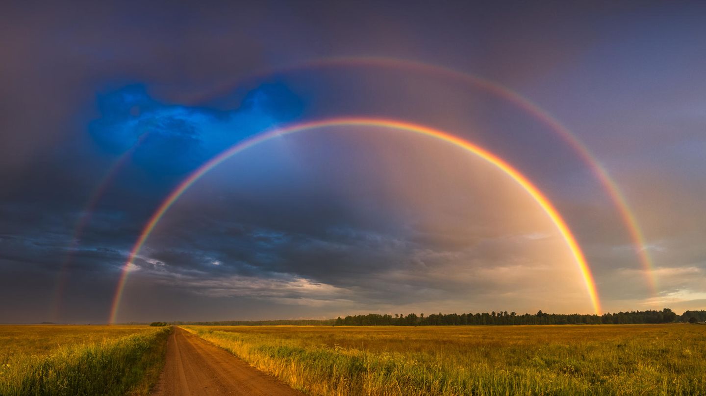 Doppelter Regenbogen über einem Feld zur Frage: Wie entsteht ein Regenbogen?