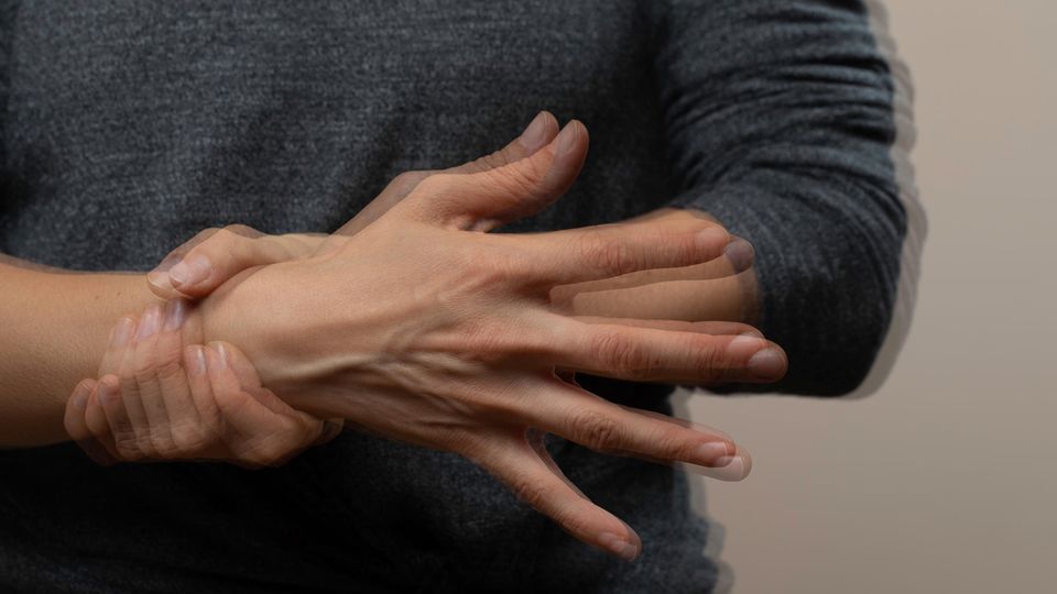 Eine Hand hält die zitternde andere Hand