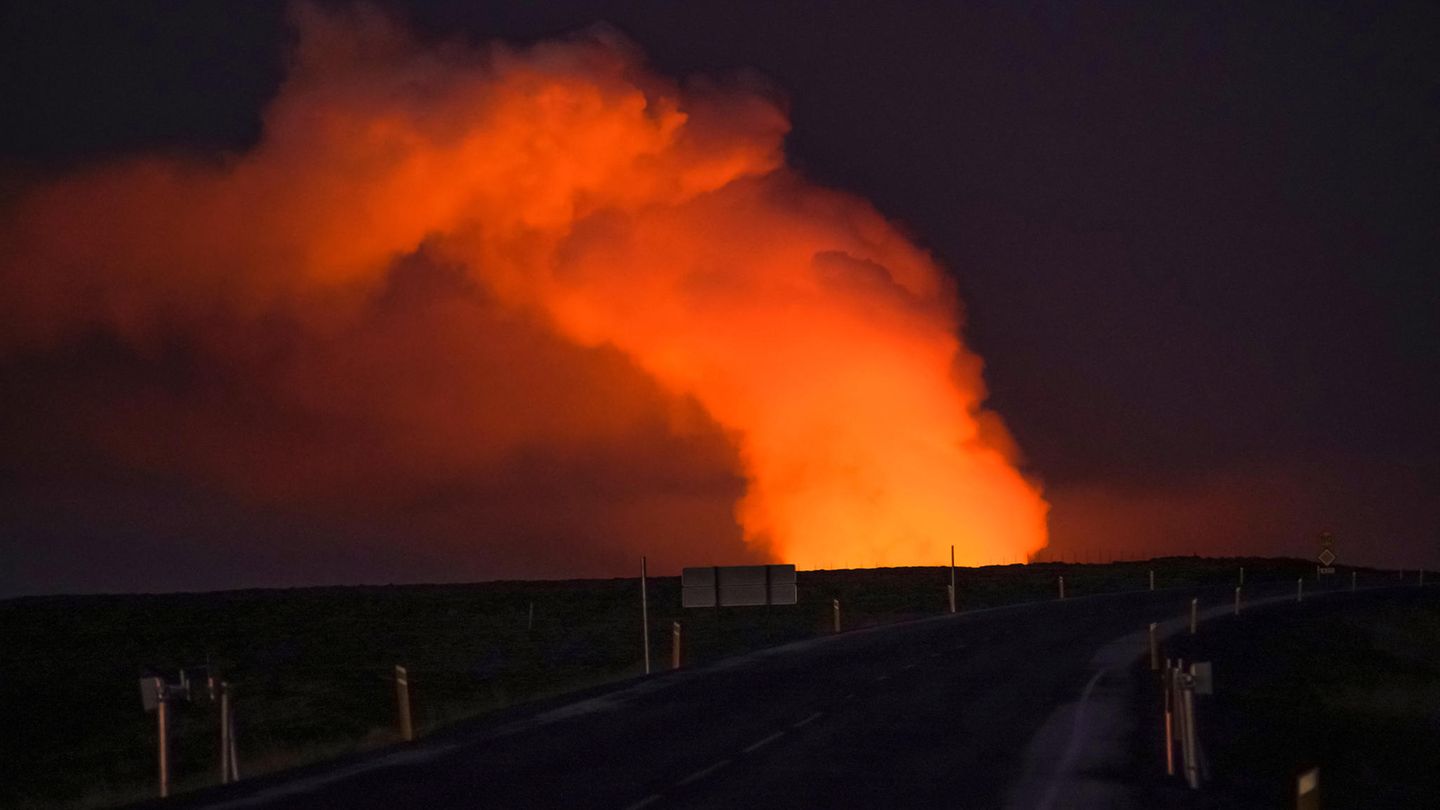 Weitgehend ruhig am Montagmorgen Straße im Dunkeln mit Feuerwolke beim Vulkanausbruch auf Island im Januar 2024