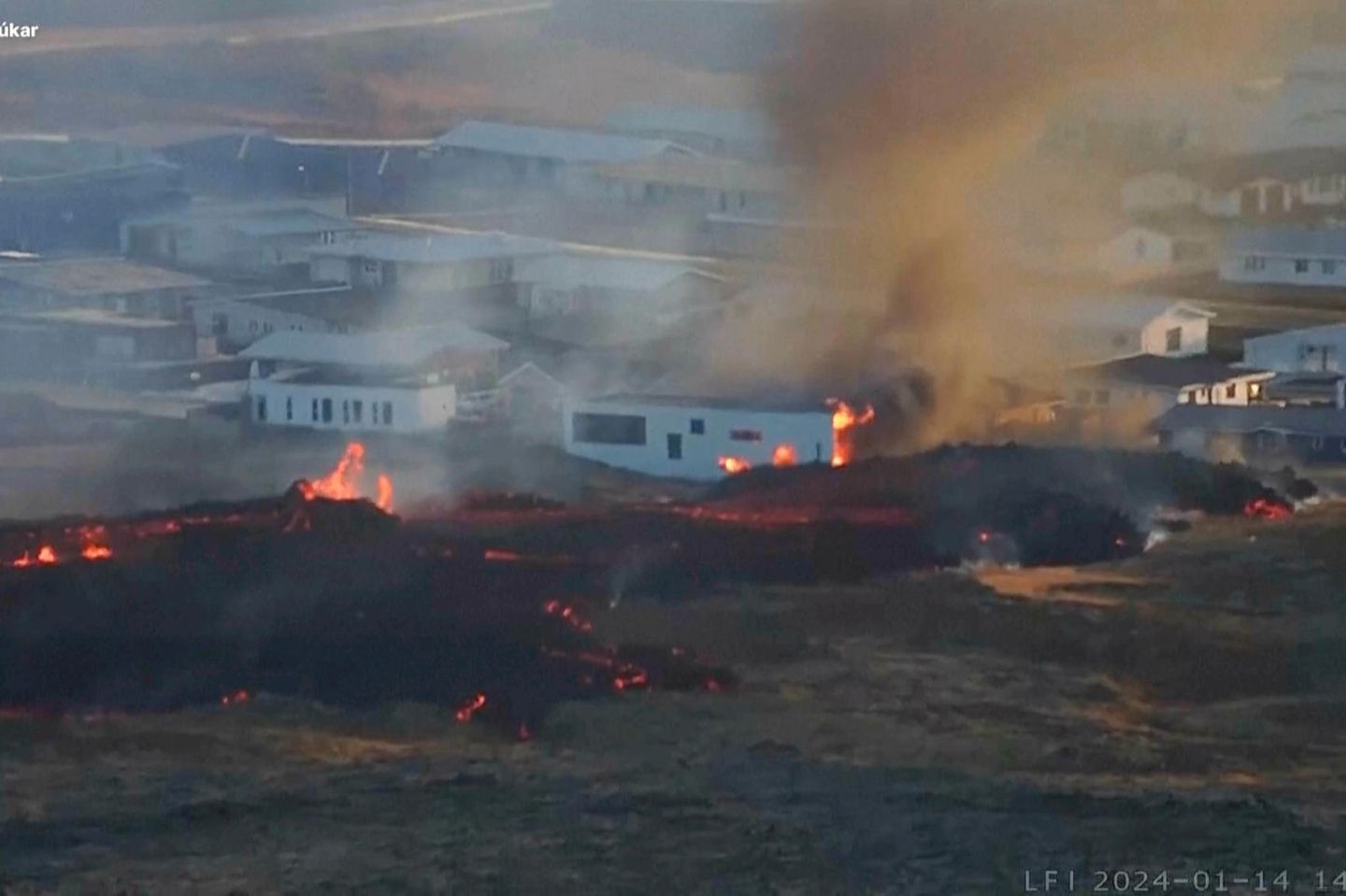 Häuser in Flammen Lava bricht neben einem Gebäude in der Nähe der Stadt Grindavík aus einem Vulkan