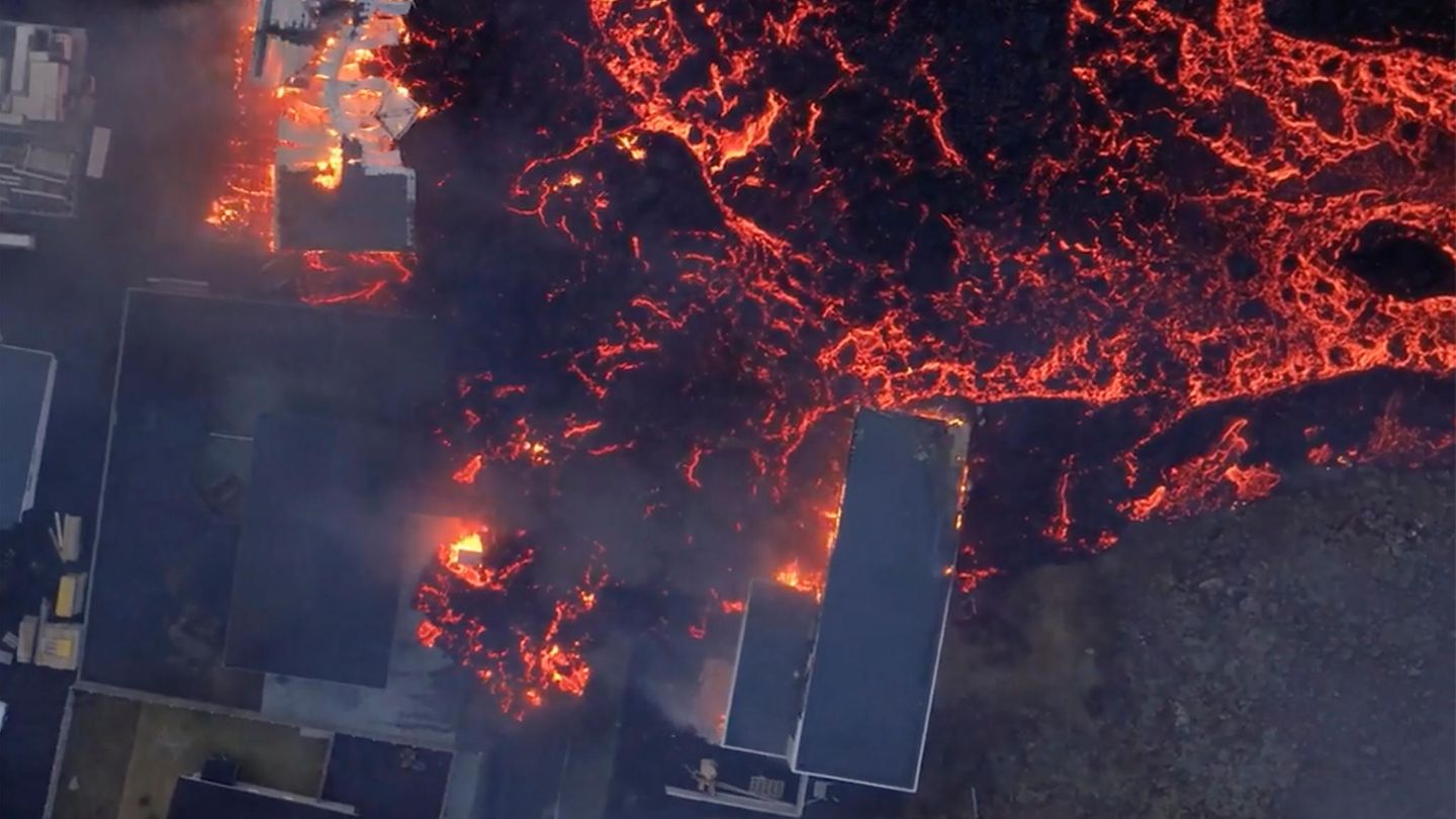 Brennende Häuser werden von Lava umflossen
