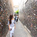 Junge Frau in einem engen hohen Gang, überall kleben bunte Kaugummis