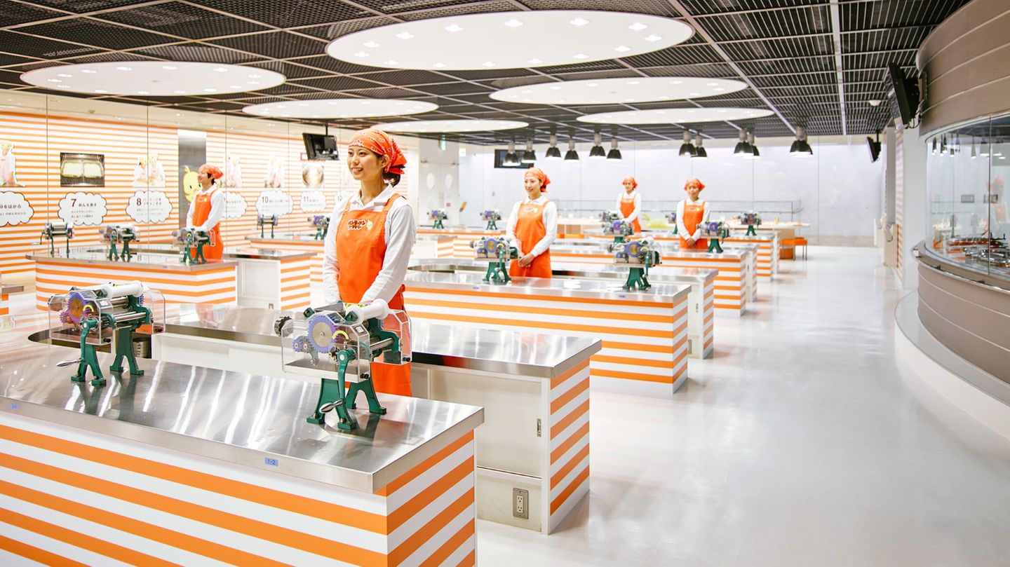 Alles Instant: Cup Noodles Museum in Osaka, Japan Junge Frauen mit Kopftüchern stehen an Nirostatischen in der Versuchsküche.