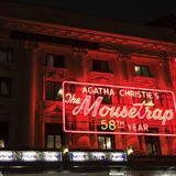 Klassizistische Theaterfassade am Abend mit großer Neonwerbung für "The Mouse Trap"