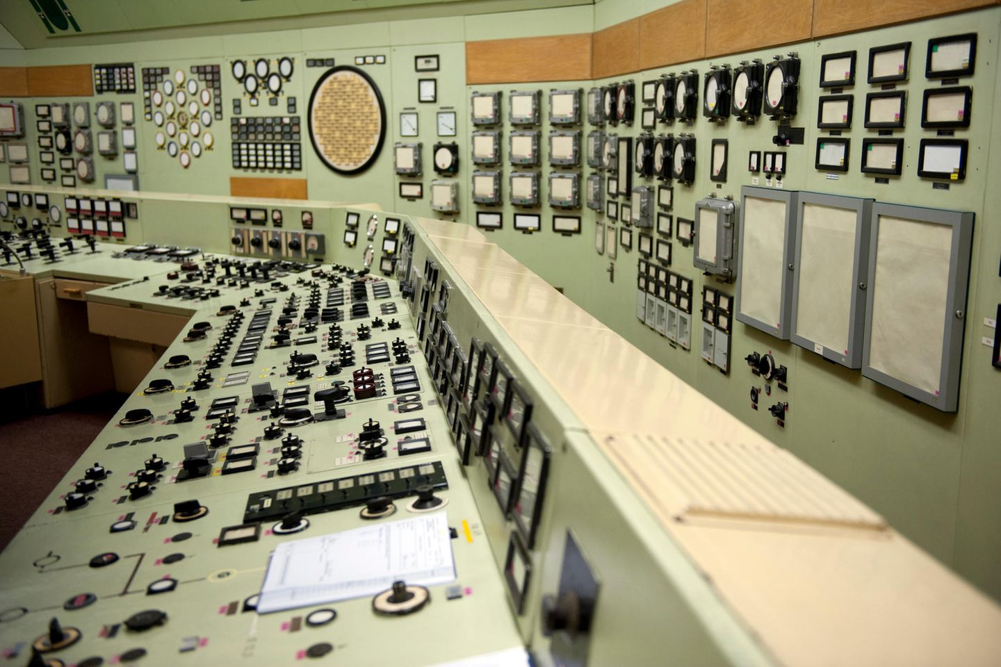 Großes Schaltpult, Kontrollinstrumente an der Wand, sehr altmodisch.