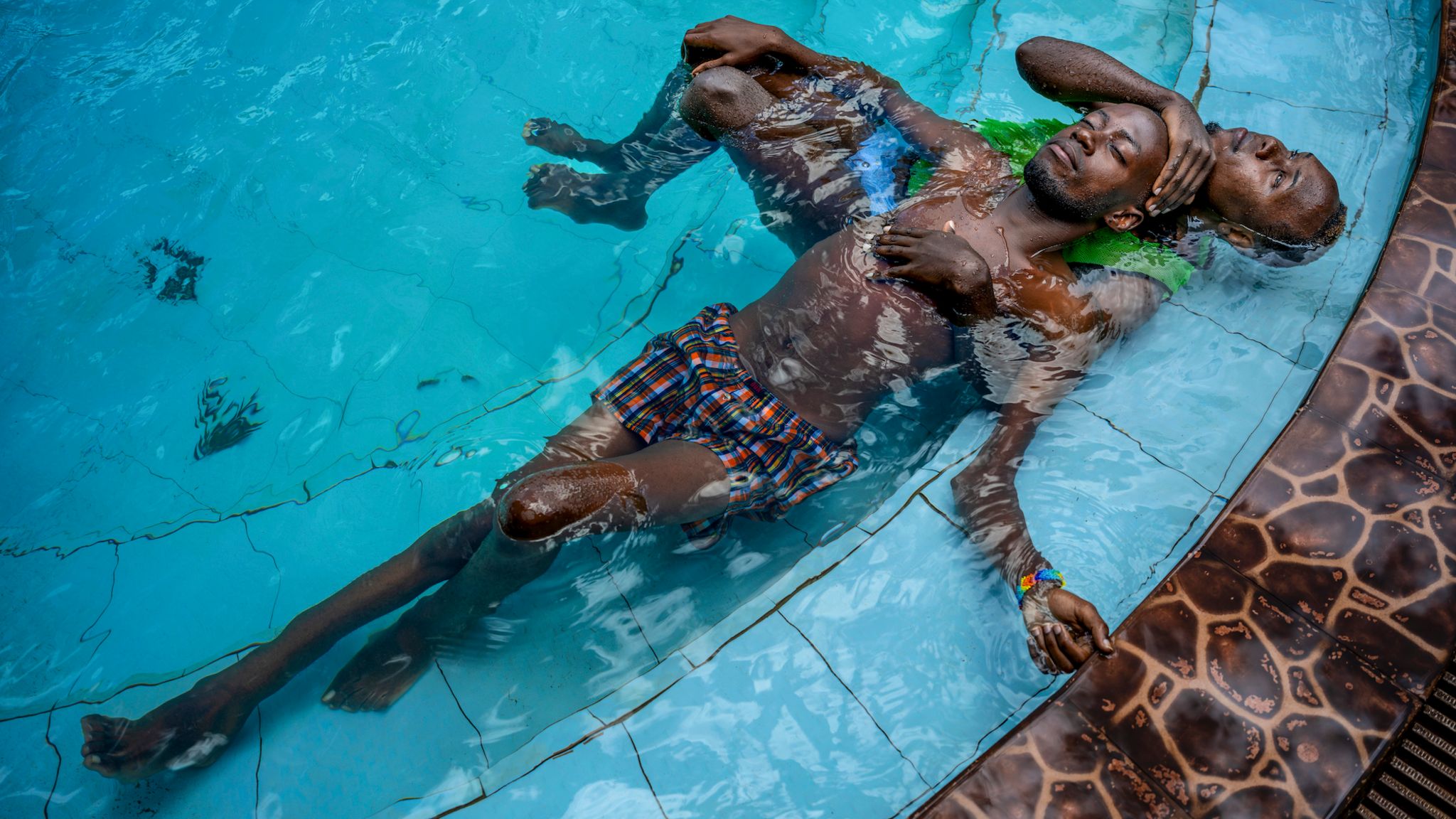 zwei Personen eng beieinander im Schwimmbecken vor oben betrachtet