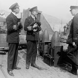 Schiffskapitän und Kommandeur halten schwarze Katzen im Arm