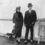 Zwei Menschen posieren auf einem Schiff, als eine Katze ins Bild läuft