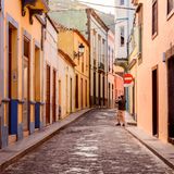 Mann in einer leeren Straße gesäumt von bunten Häusern