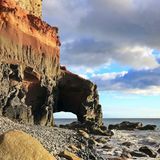 Einsamer Strand mit einem Natursteinbogen