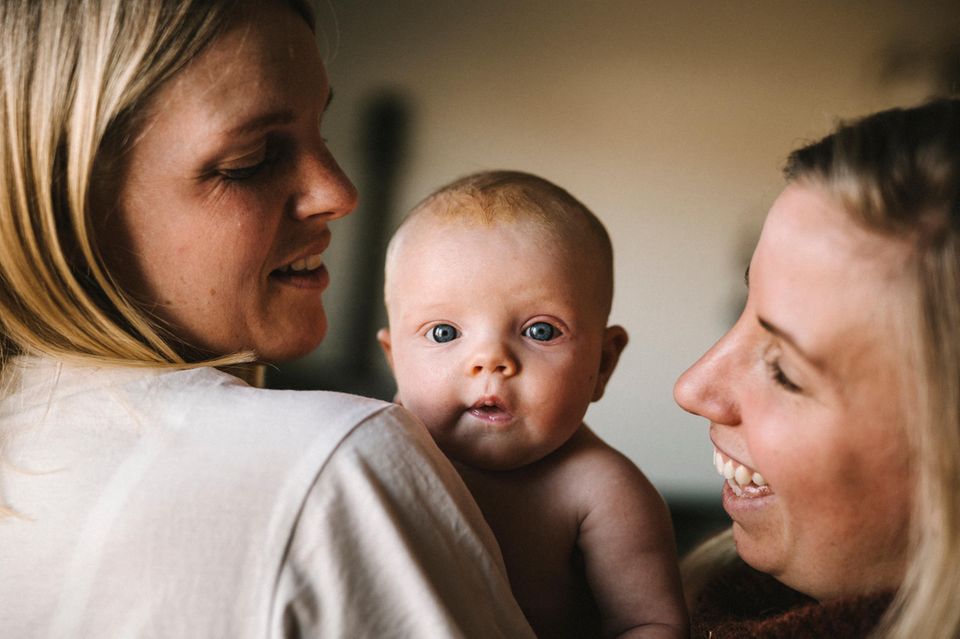 Portrait eines Babys zwischen zwei lachenden Frauen  1.4993