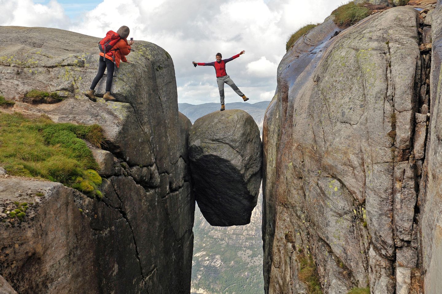 Eine Frau lässt sich am 21.08.2010 auf einem fünf Kubikmeter großen Stein im Felsplateau Kjerag (Kiragg) in Norwegen fotografieren, der in 1000 Meter Höhe über dem Lysefjord eingeklemmt hängt. Der Aufstieg zum Kjerag gilt als mühsam und dauert über zwei Stunden