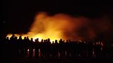 Menschenmenge vor Feuer bei Nacht