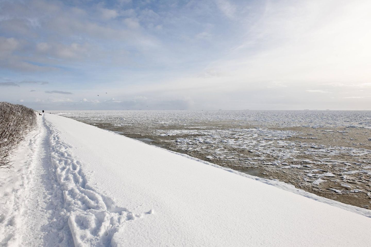 Zur linken der schneebedeckte Strand, zur rechten das Wattenmeer