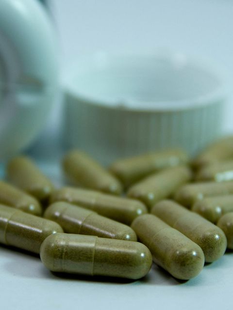 viele grüne Nahrungsergänzungskapseln liegen auf einer Fläche