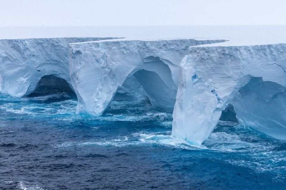 Wind und Wellen haben riesige Bögen und höhlenartige Vertiefungen in den größten Eisberg der Erde gemeißelt