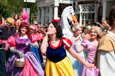 Frauen in Disney-Prinzessinnen-Kostümen, im Vordergrund Schneewittchen, die einen Luftkuss zur Seite wirft