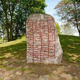 Stein umgeben von Grün, beschriftet mit roten Zeichen