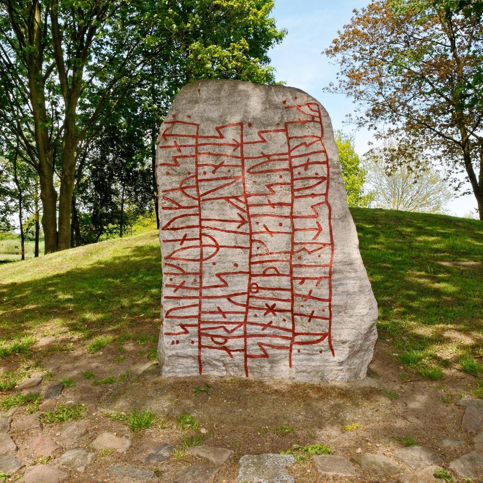 Stein umgeben von Grün, beschriftet mit roten Zeichen