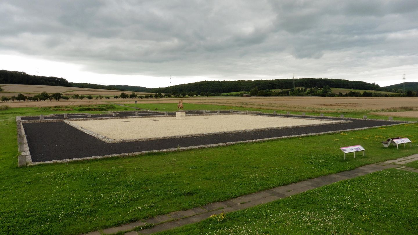 Waldgirmes: Eine andere Welt war möglich Feld und Wiese, in der Mitte befindet sich ein Quadrat, dessen Mitte eine Statue steht