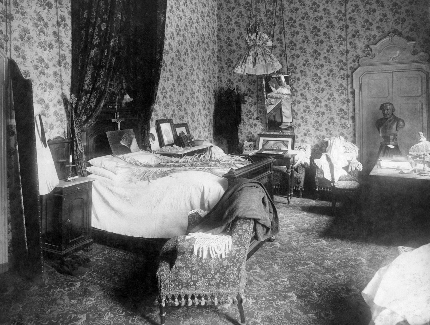 Hotelzimmer mit Bett und geblümter Tapete