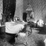 Hotelzimmer mit Bett und geblümter Tapete