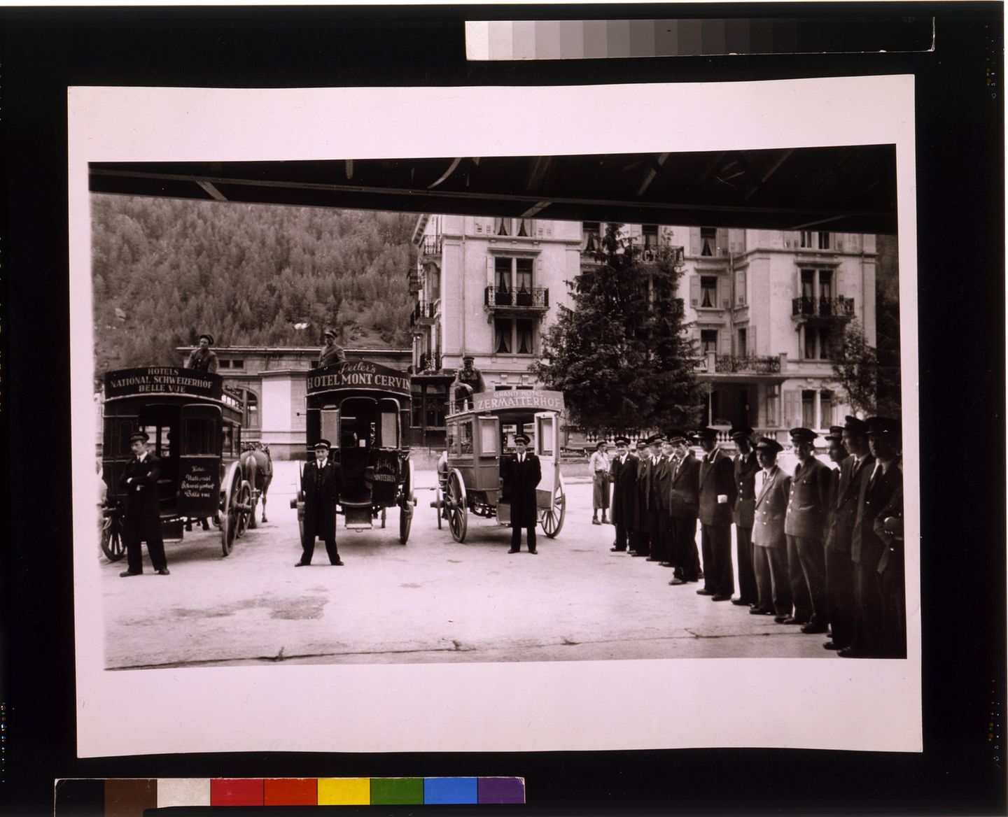 mehrere Kutschen und Portiers vor einem Gebäude