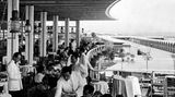 Menschen an Tischen auf einer überdachten Terrasse