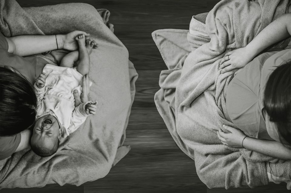 Vogelperspketive auf zwei Frauen, links mit Neugeborenem auf dem Schoß, rechts mit Schwangerschaftsbauch