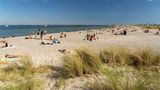 Meer-Erholung im Amager Strandpark  Meer und Sandstrand bei Sonnenschein, einige Menschen auf Decken und im Wasser