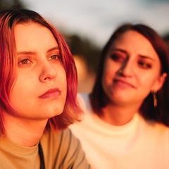Zwei Frauen sitzen nebeneinander