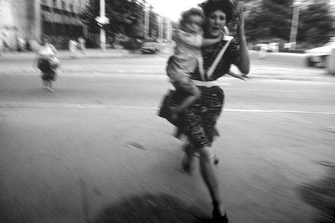 People run across an intersection to avoid sniper fire during the siege on Sarajevo by Serb troops. Around 250,000 people lost their lives in the conflict between Bosnian Muslims, Croats and Serbs that raged from 1992 to 1995 and resulted in the break-u... Eine Frau rennt mit einem Kind auf dem Arm über eine Straße