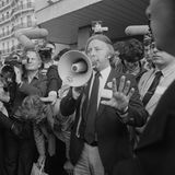 Person mit Megafon und Pressevertreter