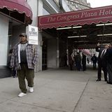 Person mit Protestschild vor Hotel