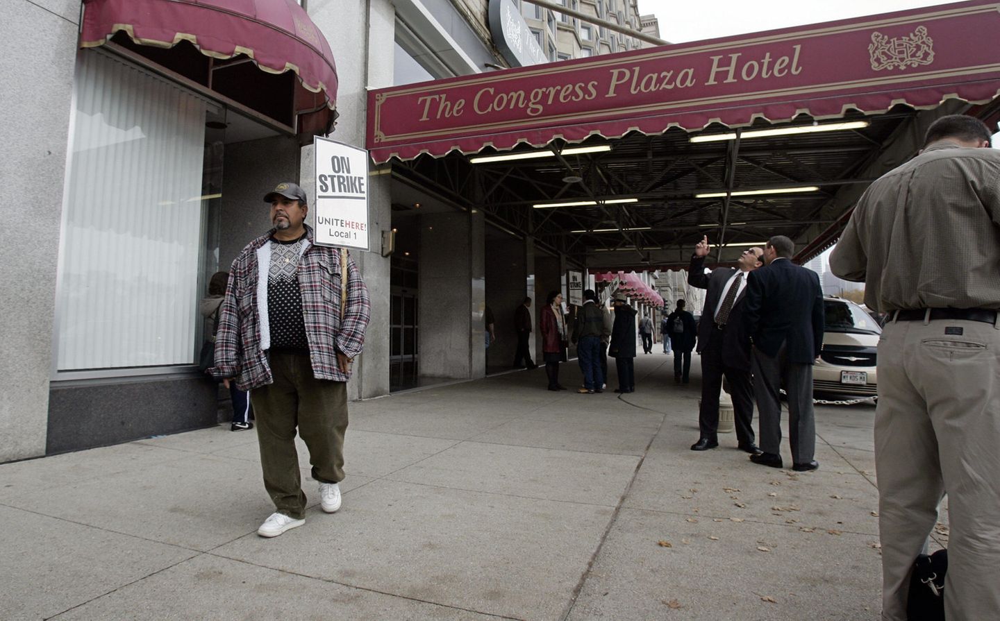 Person mit Protestschild vor Hotel