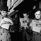 Männer lesen eine Streikzeitung