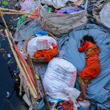 Frau liegt auf Müllbergen im Wasser