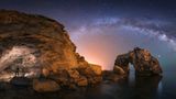 Felslandschaft und Meer mit Milchstraße und Sternenhimmel bei Nacht