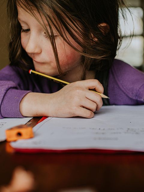 Ein Mädchen schreibt mit einem Bleisitft
