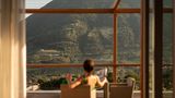 Frau blickt auf bewaldete Berge durch Fensterfront