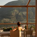 Frau blickt auf bewaldete Berge durch Fensterfront