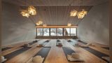 Yogaraum mit Matten und Kissen, Blick nach draußendurch Fensterfront